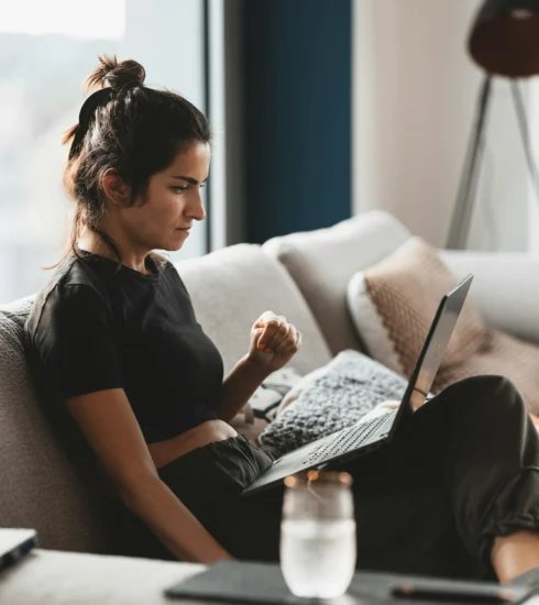 dolor de espalda en casa mujer sentada sofá molestias lumbares